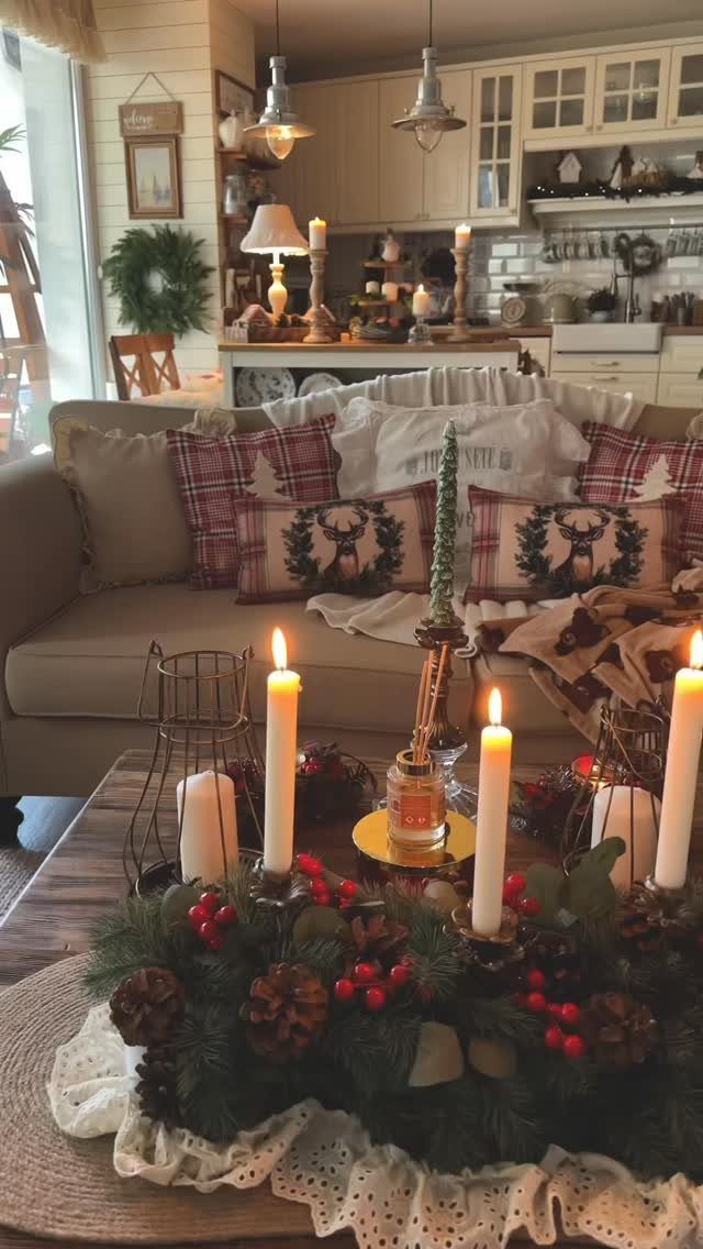 27 Christmas Display Ideas for Every Room of the Home 23 Plaid pillows and lit candles on a coffee table in a cozy farmhouse living room.