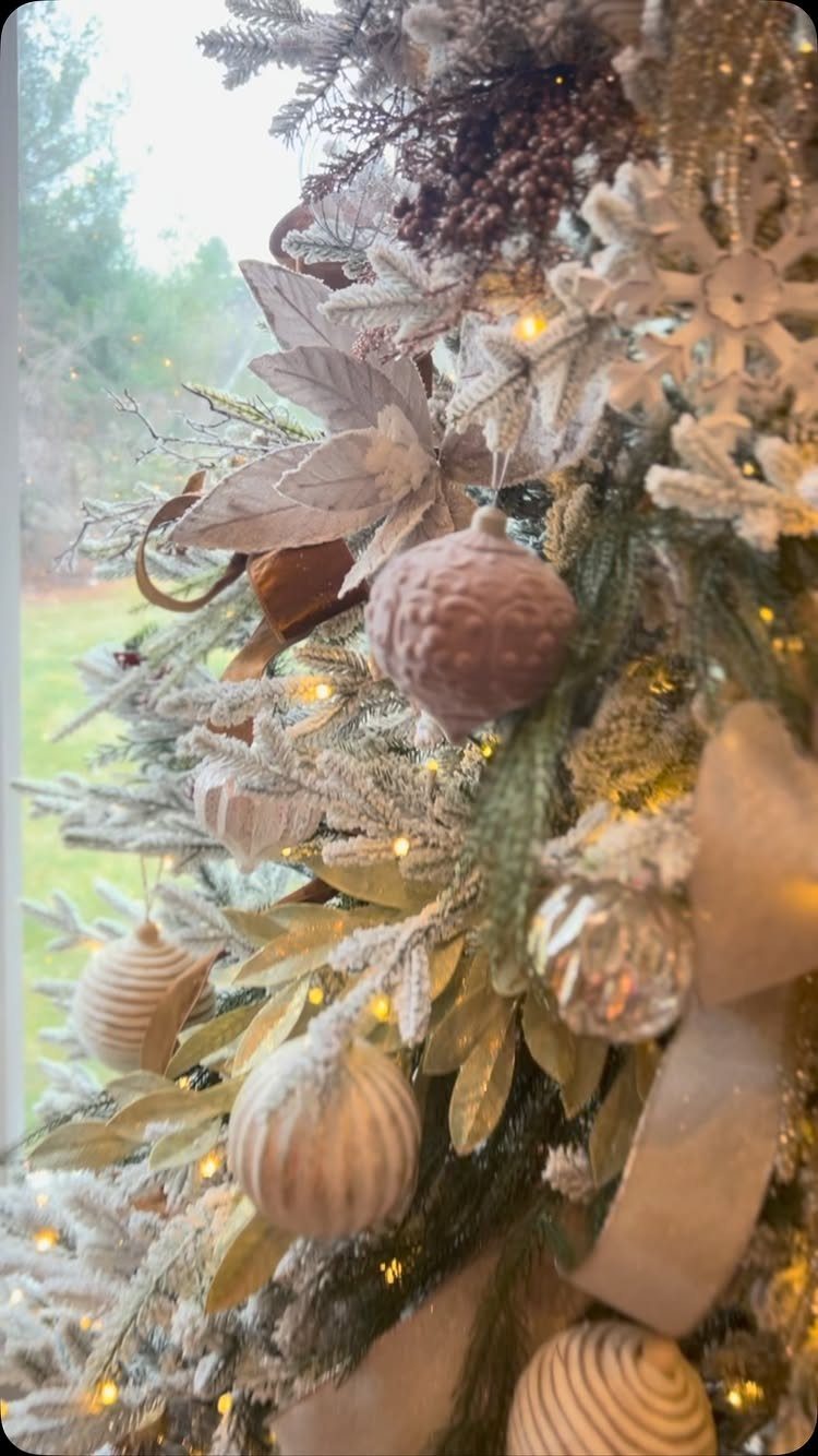 27 Christmas Display Ideas for Every Room of the Home 22 Cream and beige Christmas ornaments nestled among frosted greenery and twinkling fairy lights.