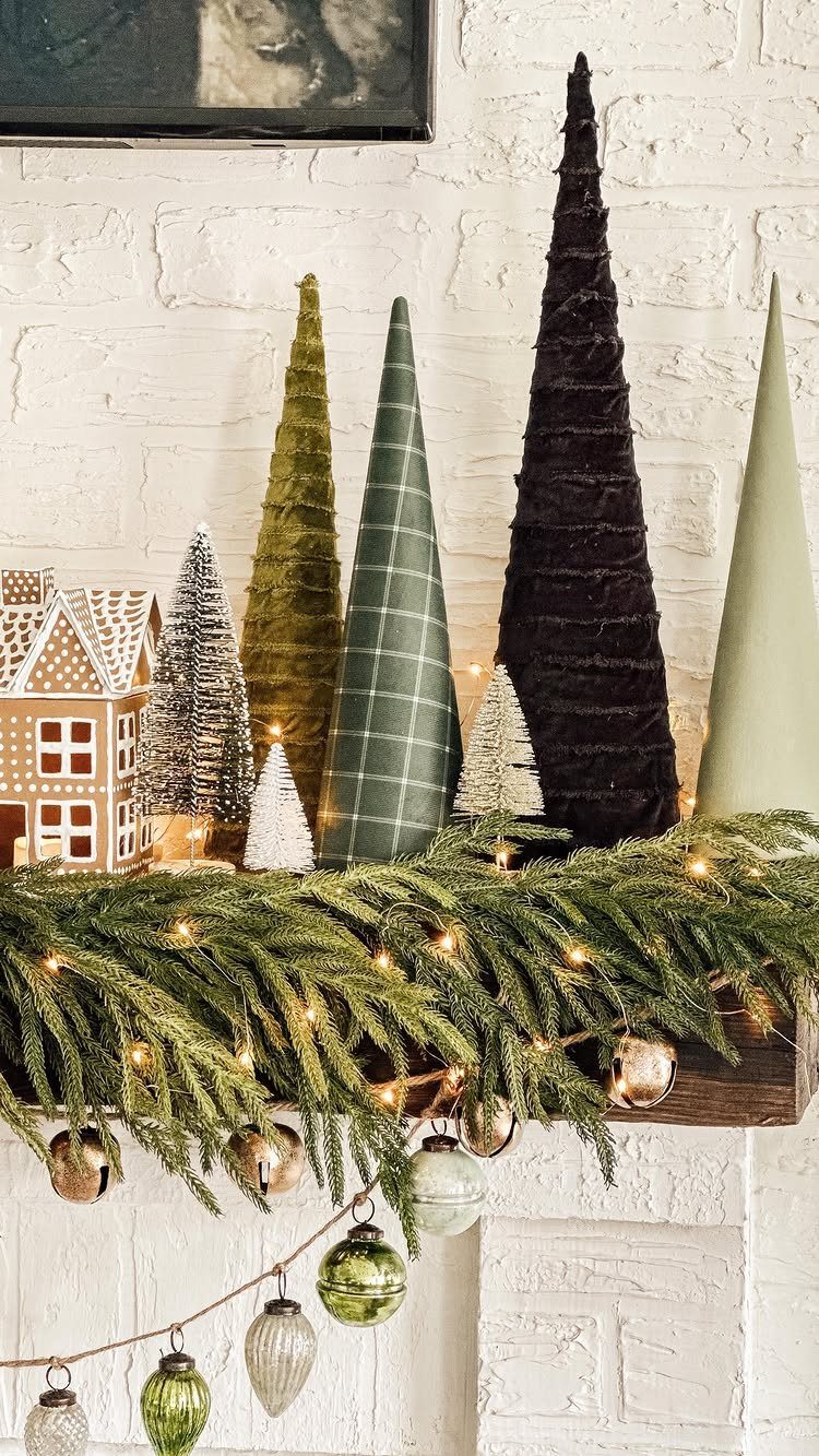 Conical minimalist trees in various colors and patterns arranged on a decorated mantelpiece.