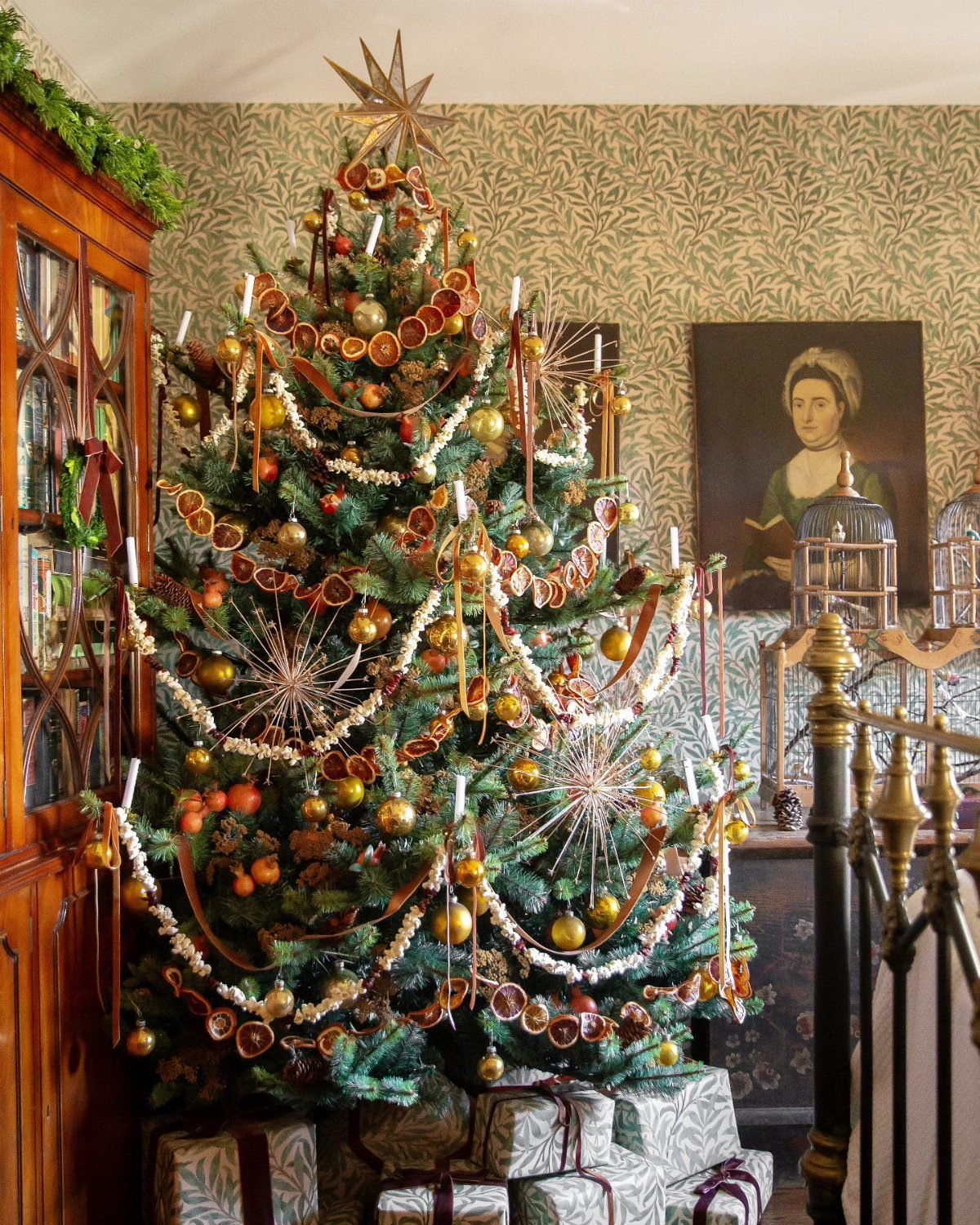 Christmas Tree Decor Ideas for 2025: 17 Fresh Styles from Coastal to Candyland 15 Decorated Christmas tree with dried orange slices, white garlands, and candles in a vintage room.