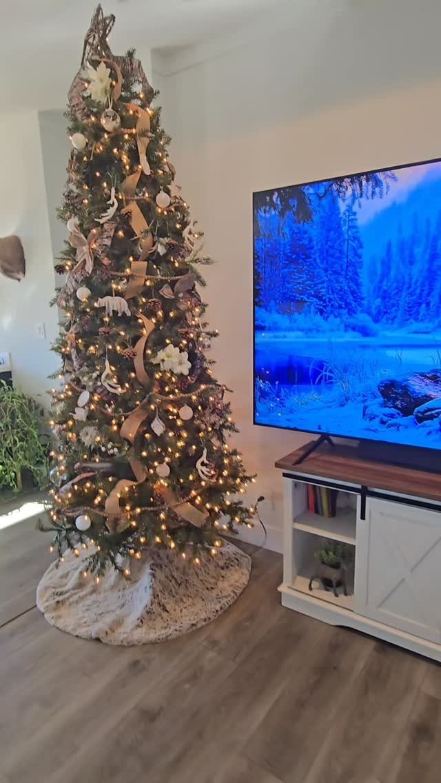 Christmas Tree Decor Ideas for 2025: 17 Fresh Styles from Coastal to Candyland 16 Decorated Christmas tree with warm lights, burlap ribbons, and white animal ornaments on a faux fur skirt.