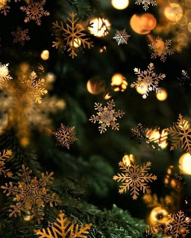 Christmas Wallpaper Backgrounds iPhone: 8 Styles for Your Screen 8 Golden snowflakes floating over a dark Christmas tree with warm glowing bokeh lights.
