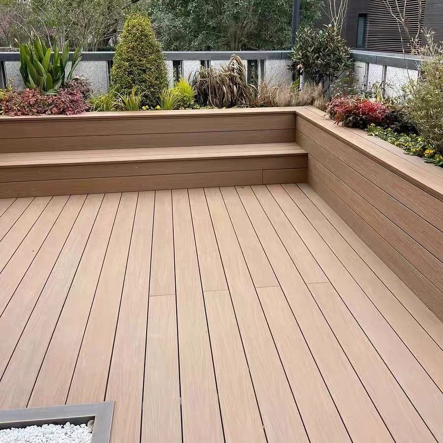 Composite Wood Deck 13 Ideas for Plans, Patterns and Colors 4 Light brown composite wood decking with built-in benches and garden planters in an outdoor setting.