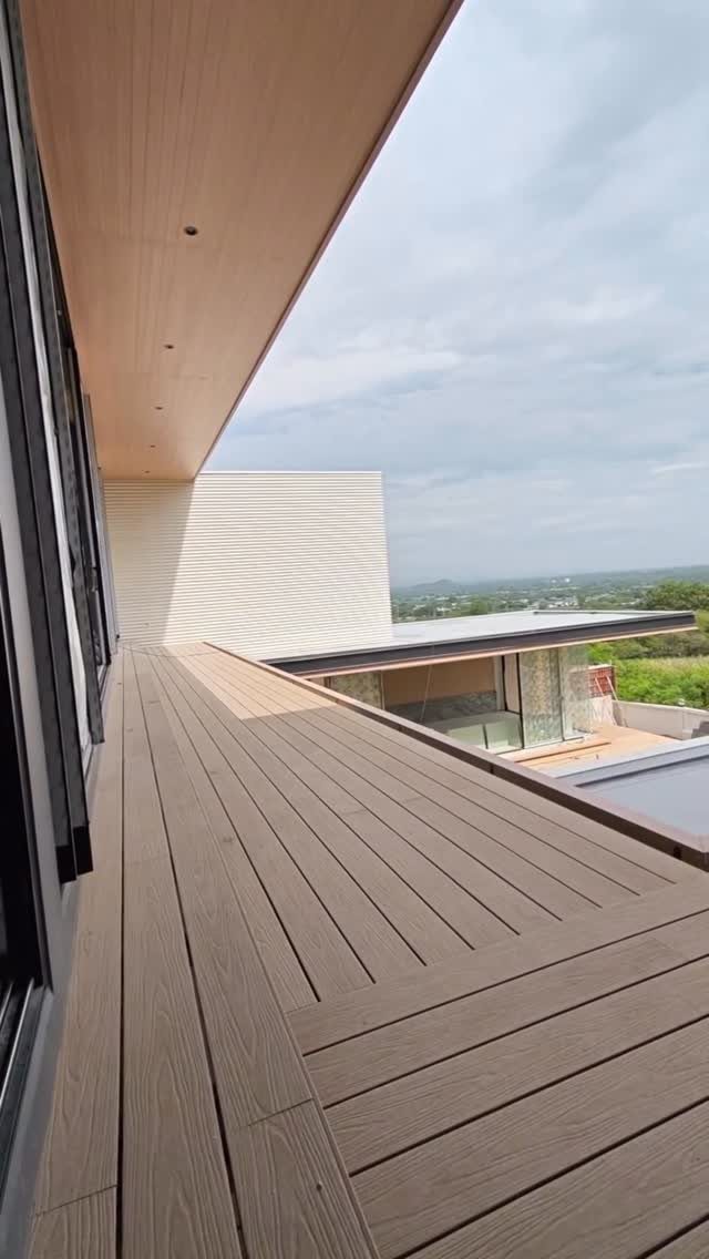 Composite Wood Deck 13 Ideas for Plans, Patterns and Colors 12 Light brown composite wood decking on a modern balcony overlooking a distant landscape.