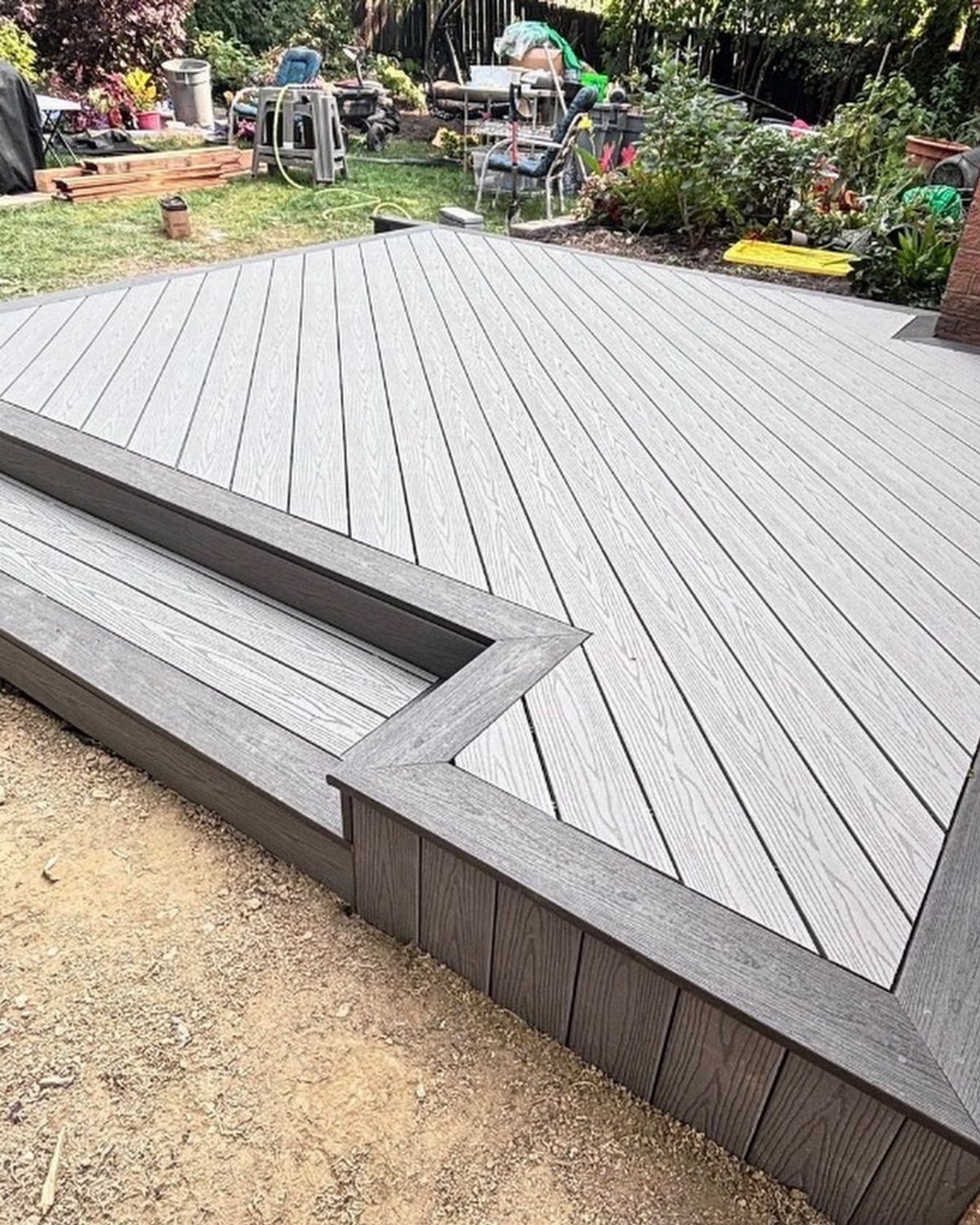 Composite Wood Deck 13 Ideas for Plans, Patterns and Colors 6 A newly installed grey composite wood deck with diagonal plank patterns and dark brown trim boards.