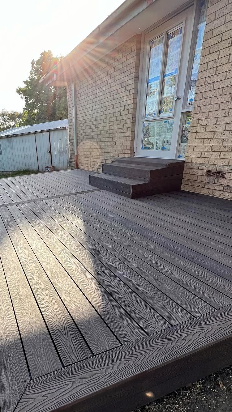 Composite Wood Deck 13 Ideas for Plans, Patterns and Colors 3 Dark grey textured composite wood decking installed against a brick house with small steps.