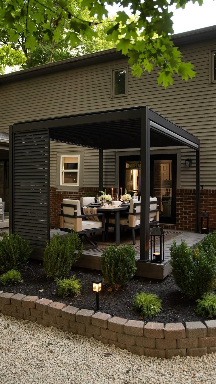 A black pergola sheltering a dining table with cream chairs on a wooden deck.