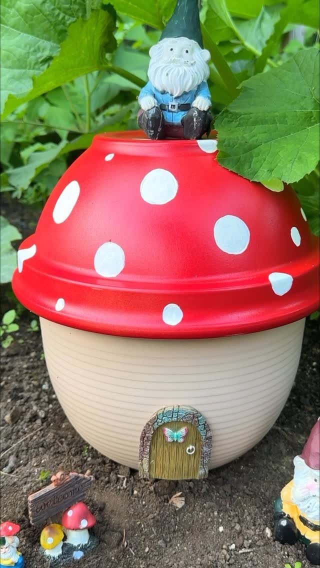 8 DIY Garden Projects for Fairy Gardens, Raised Beds and Outdoor Play 3 A large red mushroom ceramic house with a small gnome sitting on top in a garden.