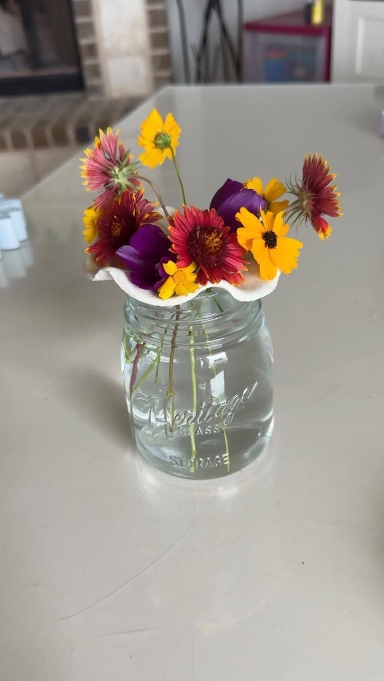 8 DIY Garden Projects for Fairy Gardens, Raised Beds and Outdoor Play 5 Colorful wildflowers arranged in a clear glass mason jar on a white countertop.