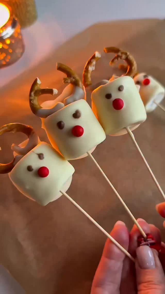 32 Easy Christmas Party Ideas for Food, Drinks, and Hosting in 2026 23 Three white chocolate covered marshmallow reindeer treats with pretzel antlers on sticks.