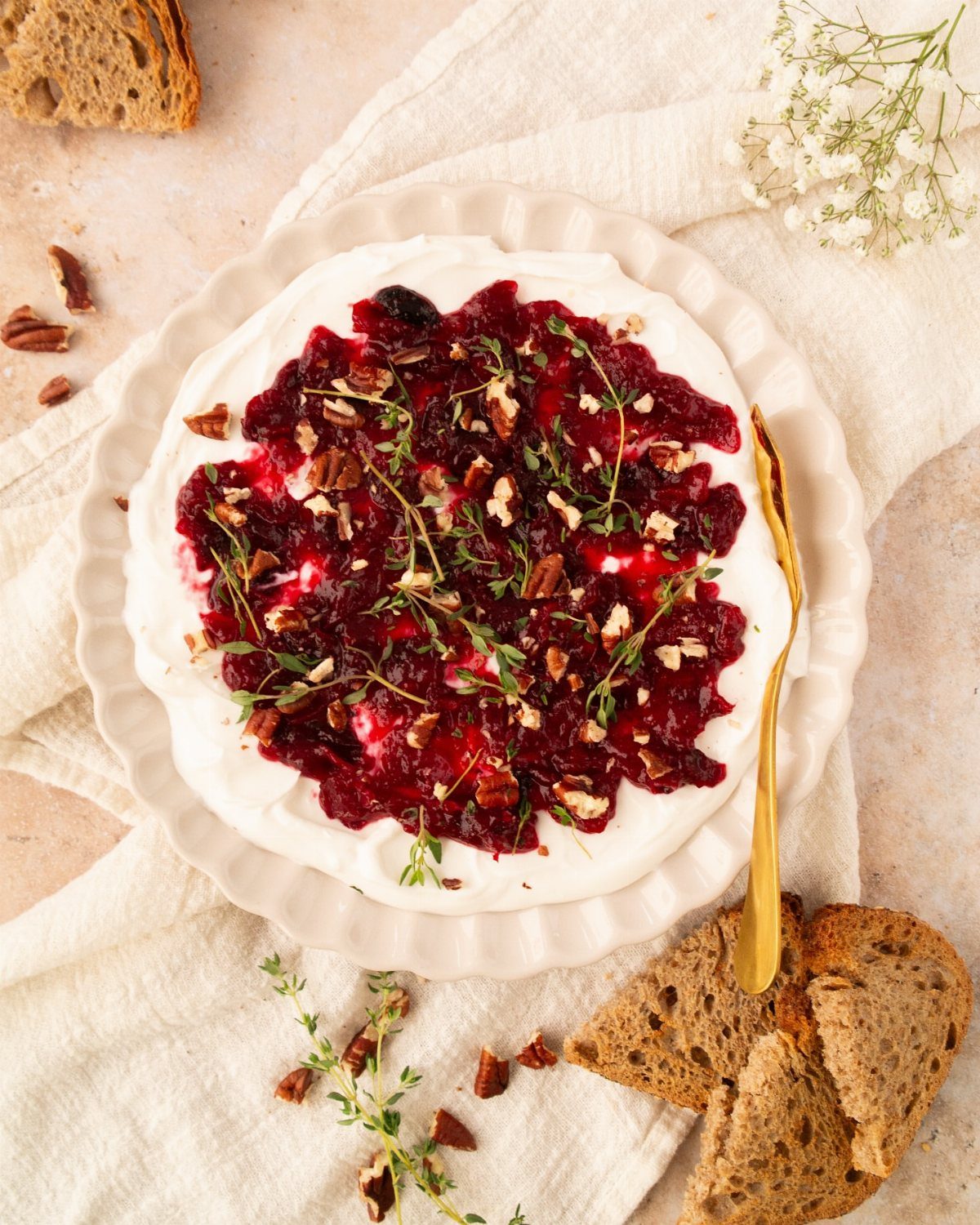 32 Easy Christmas Party Ideas for Food, Drinks, and Hosting in 2026 9 Cranberry cream cheese dip topped with nuts and thyme served with toasted bread slices.