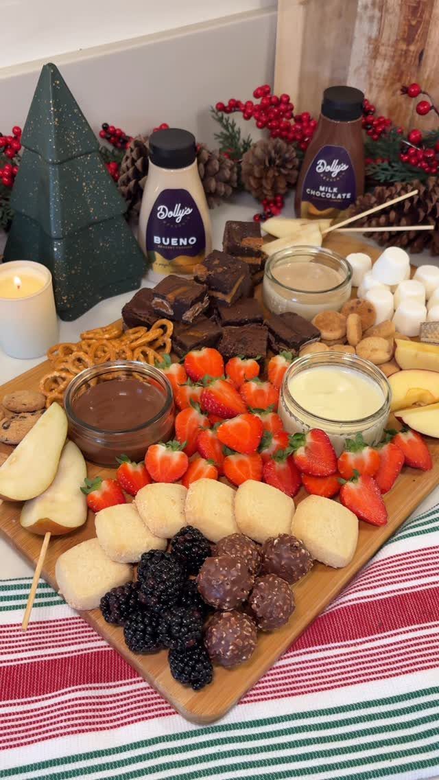 32 Easy Christmas Party Ideas for Food, Drinks, and Hosting in 2026 11 A wooden dessert board featuring strawberries, brownies, marshmallows, and various dipping sauces.