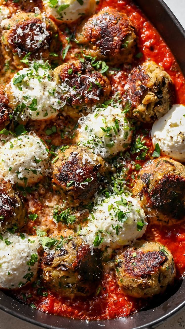 32 Easy Christmas Party Ideas for Food, Drinks, and Hosting in 2026 30 Meatballs in tomato sauce topped with ricotta cheese and fresh herbs in a pan.