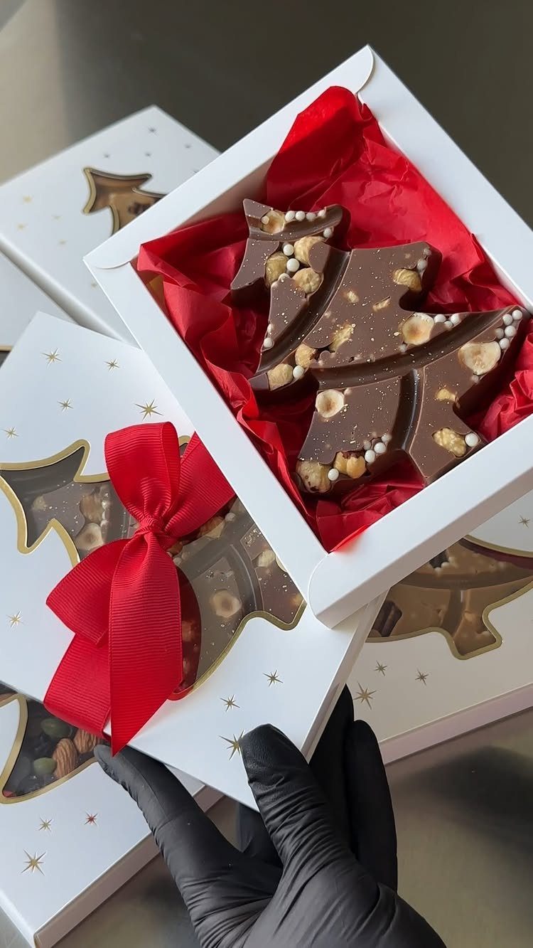 17 Easy DIY Christmas Gifts: Handmade Presents for Every List 16 Chocolate tree-shaped treats in white gift boxes with red tissue paper and ribbons.