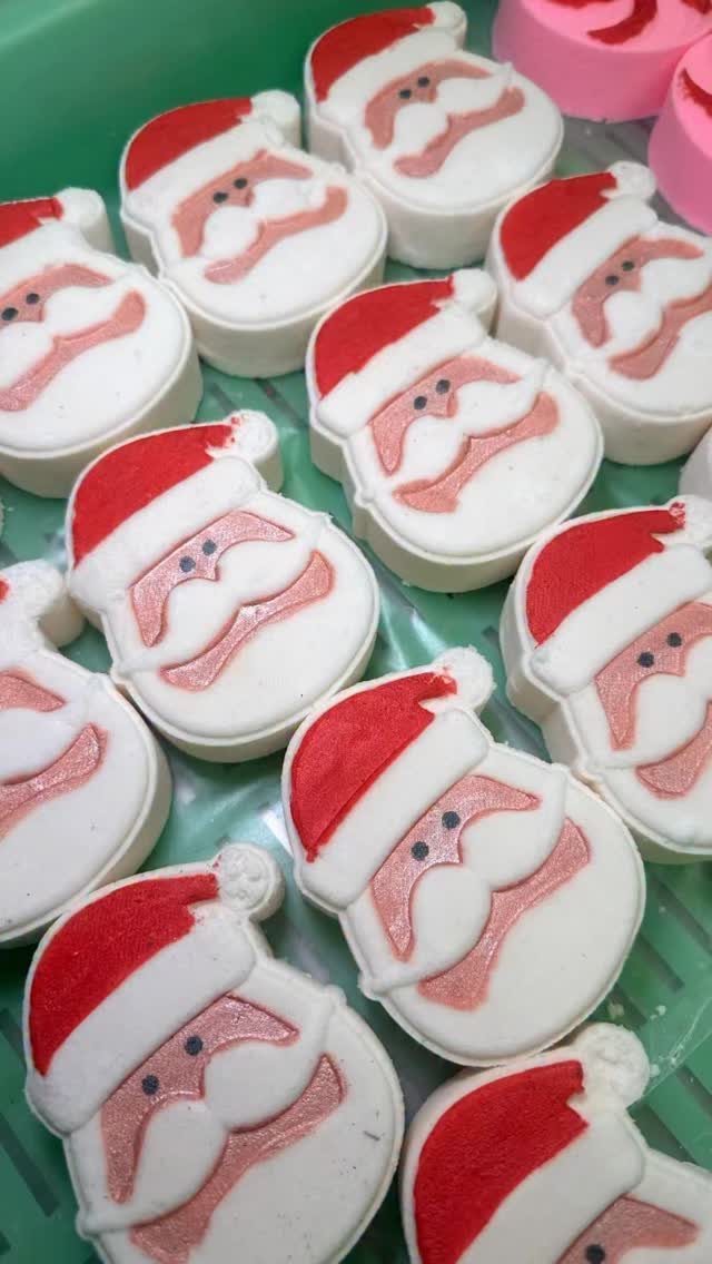 17 Easy DIY Christmas Gifts: Handmade Presents for Every List 6 Santa Claus shaped white bath bombs with red hats arranged in a green tray.