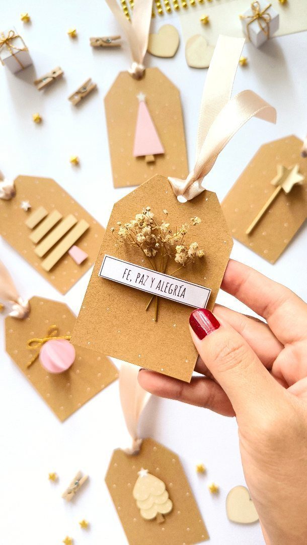 17 Easy DIY Christmas Gifts: Handmade Presents for Every List 8 A hand holding a decorated brown kraft paper gift tag with dried flowers.