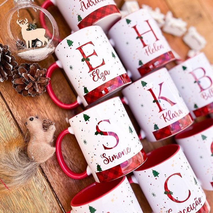 17 Easy DIY Christmas Gifts: Handmade Presents for Every List 2 Personalized white Christmas mugs with red handles and names arranged on a wooden table.