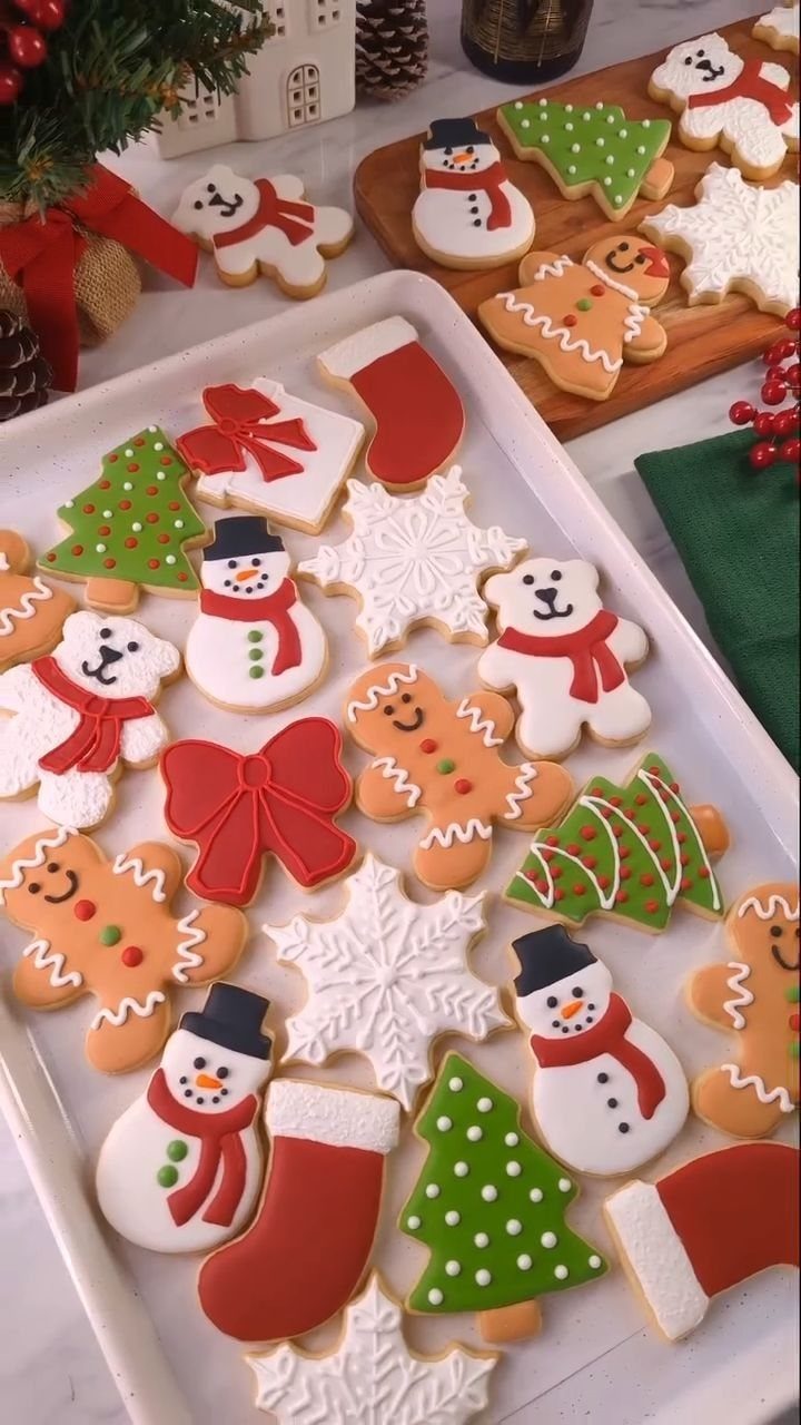 17 Easy DIY Christmas Gifts: Handmade Presents for Every List 17 Decorated Christmas cookies in various festive shapes arranged on a white tray and wooden board.