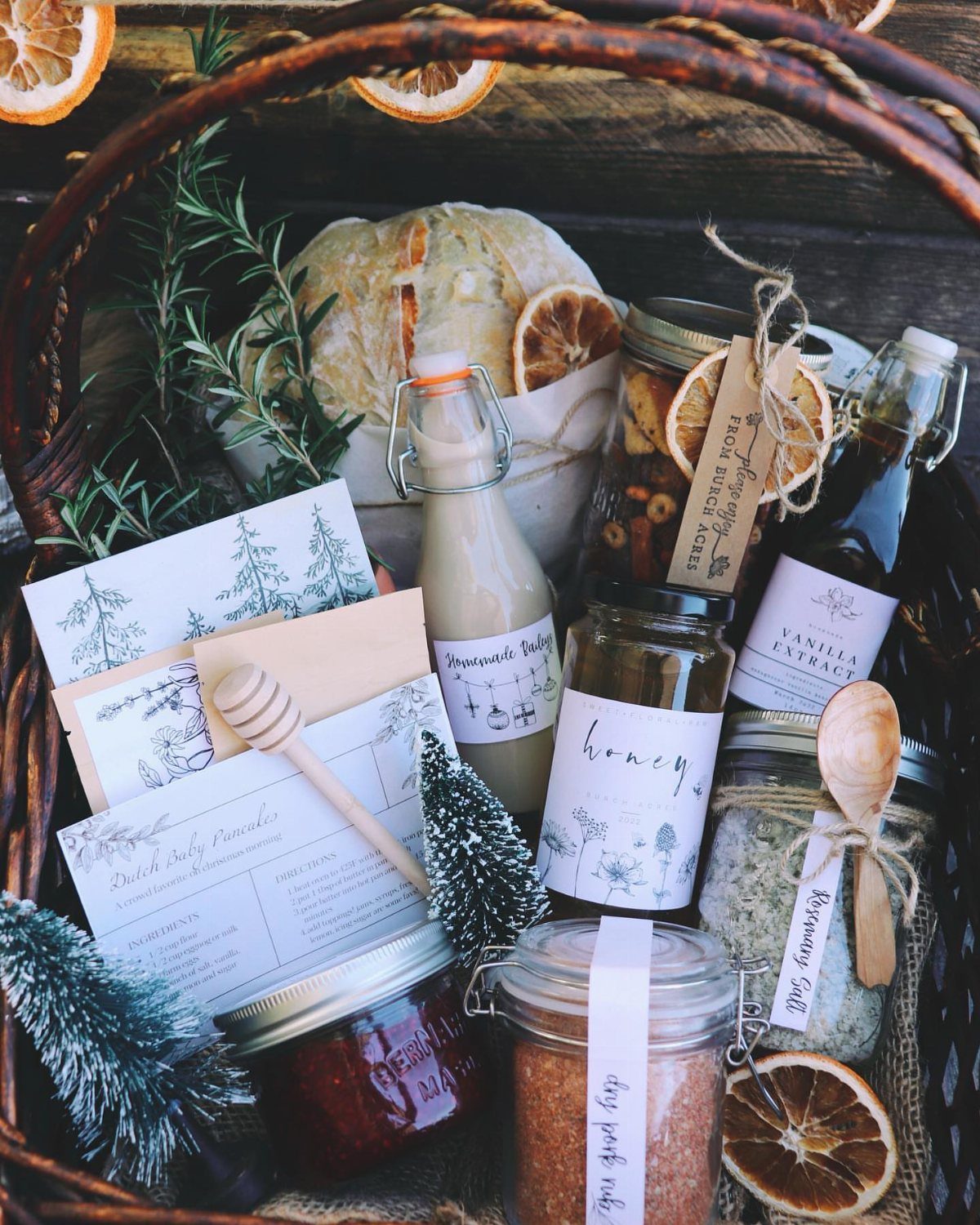 17 Easy DIY Christmas Gifts: Handmade Presents for Every List 9 A wicker basket containing various homemade food gifts, glass jars, and dried citrus slices.