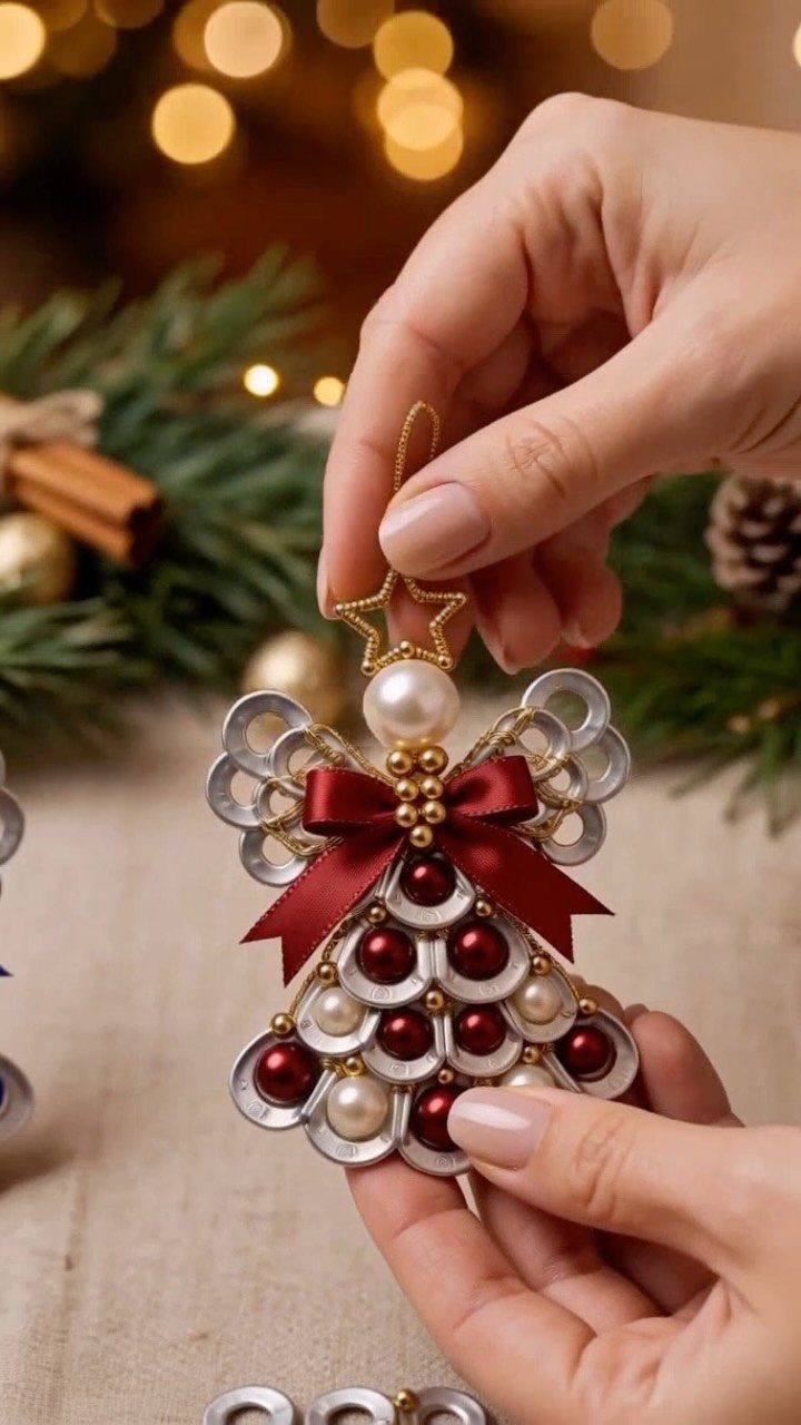 17 Easy DIY Christmas Gifts: Handmade Presents for Every List 12 Hands holding a handmade angel ornament crafted from metal pull tabs and decorative pearls.