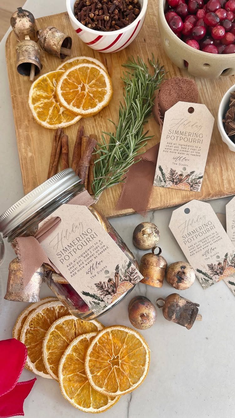 Dried orange slices, rosemary, cinnamon, and cranberries arranged with a mason jar of simmering potpourri.