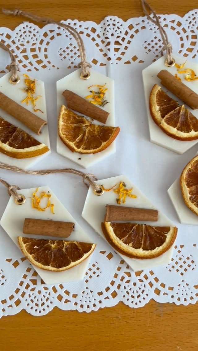Hexagonal white wax melts decorated with dried orange slices and cinnamon sticks on lace.