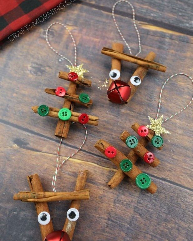 Cinnamon stick ornaments shaped like reindeer and Christmas trees on a wooden surface.
