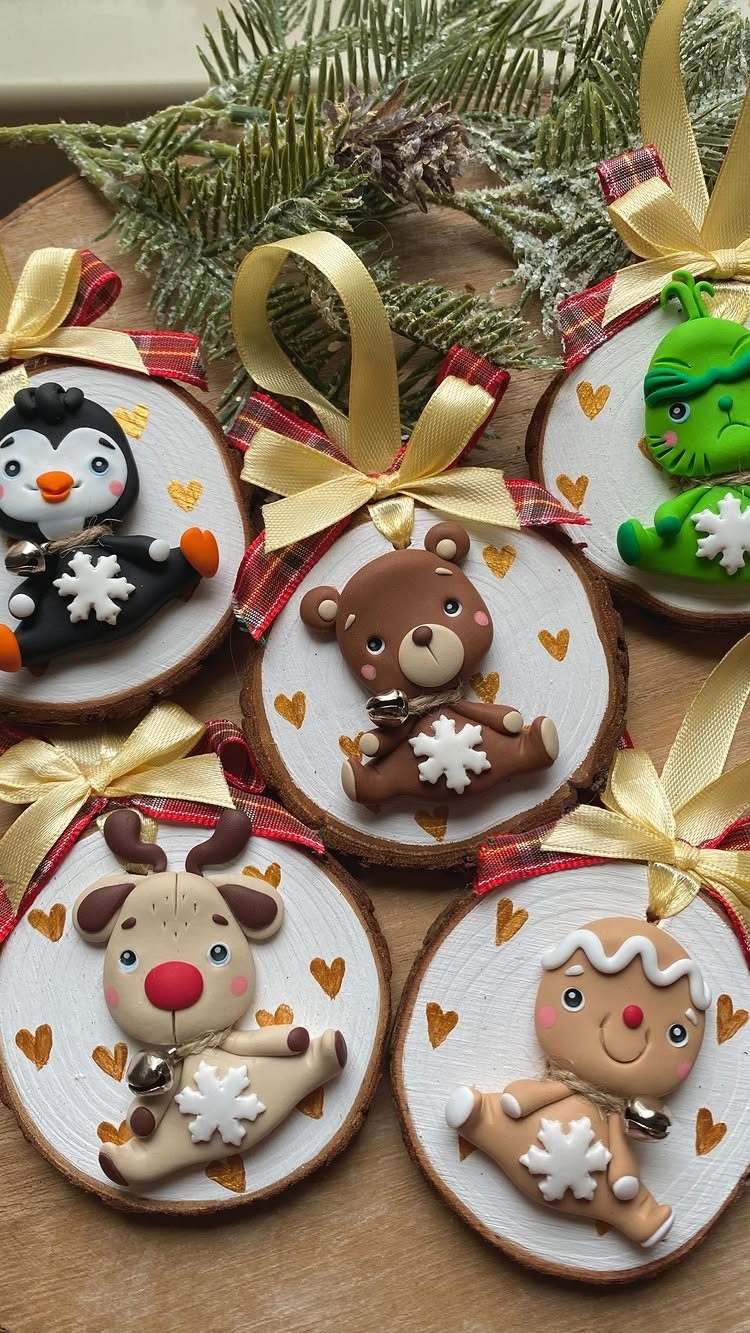 Five wooden slice ornaments featuring various cute clay animals and a gingerbread man decorated with snowflakes.