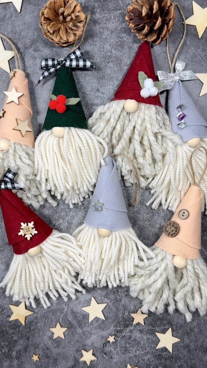 26 Handmade Ornaments: DIY Projects from Paper to Pinecones 6 Handmade felt gnome ornaments with yarn beards and pointed hats on a grey background.