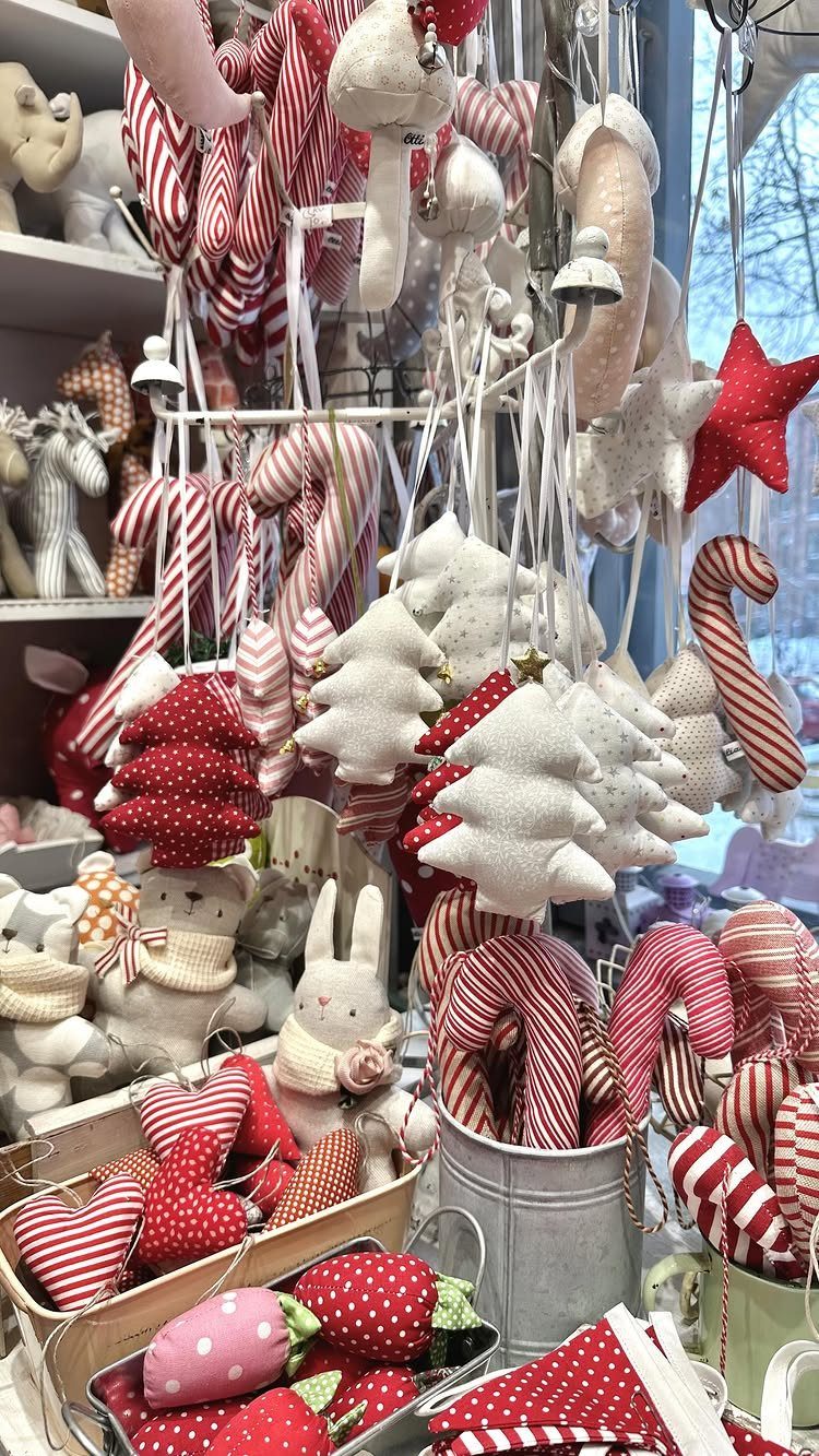 26 Handmade Ornaments: DIY Projects from Paper to Pinecones 4 Handmade fabric Christmas ornaments including candy canes, stars, and trees hanging in a shop display.