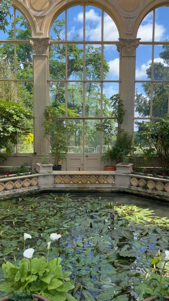 Interesting Garden Ideas: 9 Spaces That Pull You In 5 A lily pond with white flowers viewed through large arched windows of an orangery.