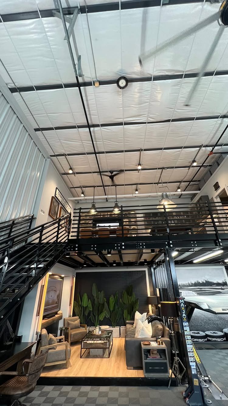 Modern garage interior featuring a living room area underneath a black metal loft structure.