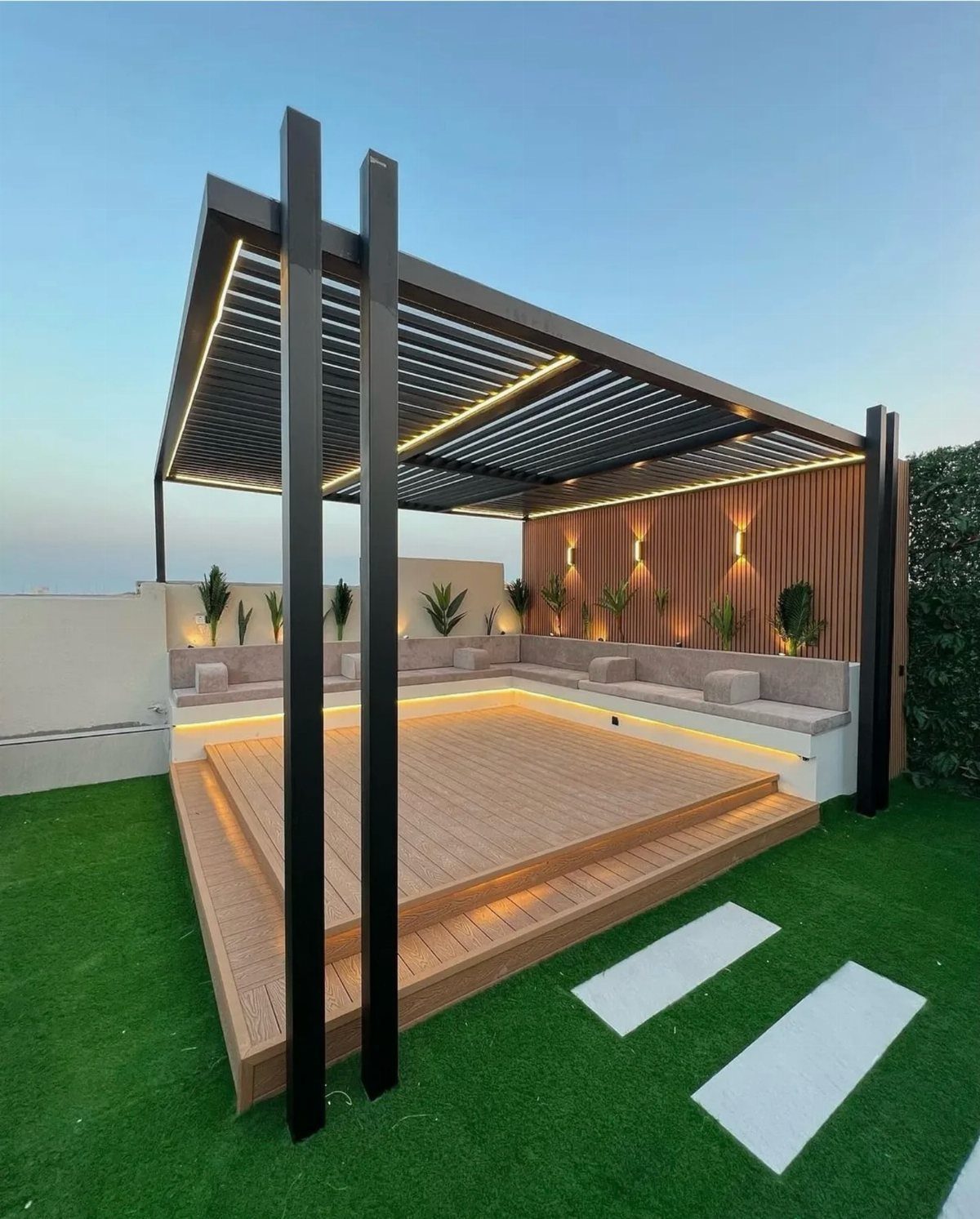 Modern wooden deck with a black pergola, built-in seating, and integrated LED lighting.