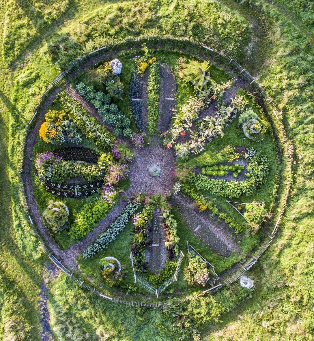 13 Unique Garden Ideas for Planters, Privacy Screens and Pallet Projects 8 Aerial view of a large circular mandala garden with symmetrical plant sections and paths.