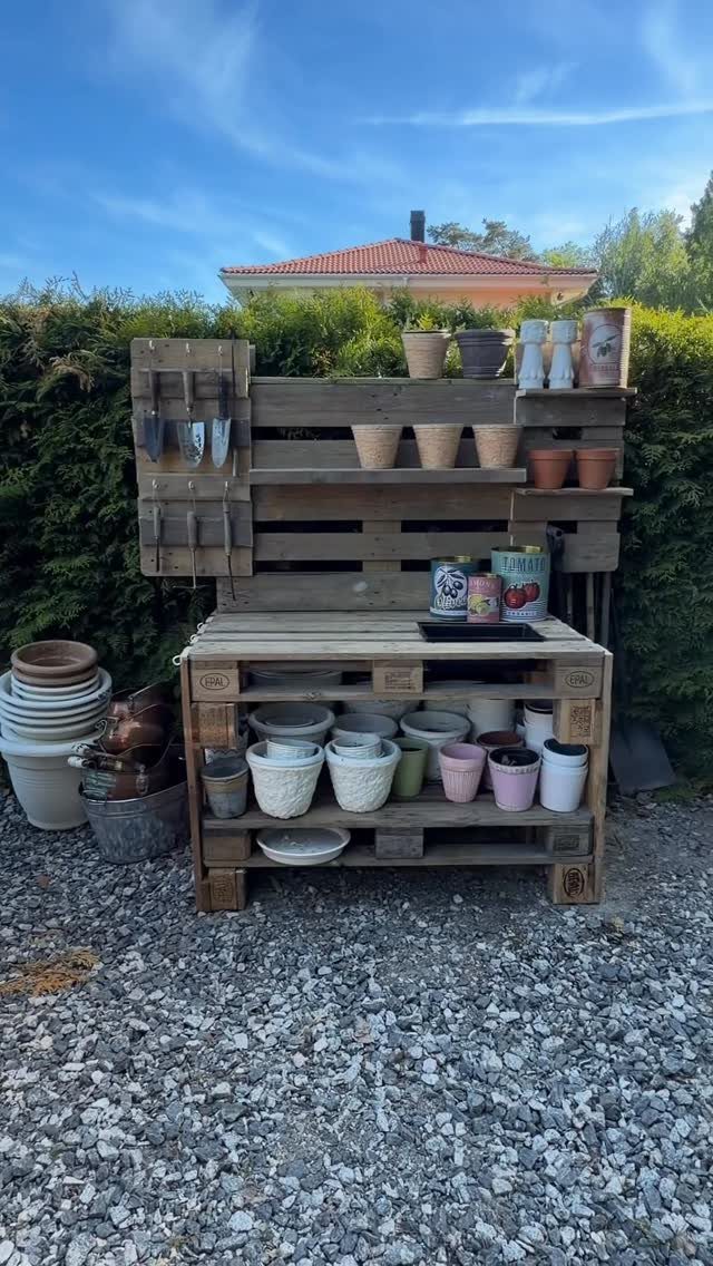 13 Unique Garden Ideas for Planters, Privacy Screens and Pallet Projects 5 A wooden pallet potting bench filled with various ceramic and terracotta plant pots outdoors.