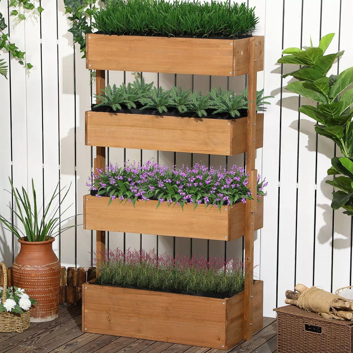 Wooden four-tier planter stand with green plants and purple flowers against a white fence.