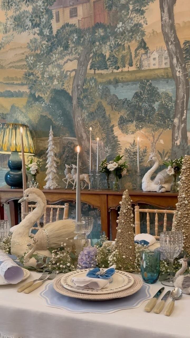12 Xmas Table Decorations for Pine Cones, Mercury Glass, and Blue-Gold Palettes 12 A decorated Christmas table featuring white plates, blue accents, greenery, and sparkling gold cone trees.