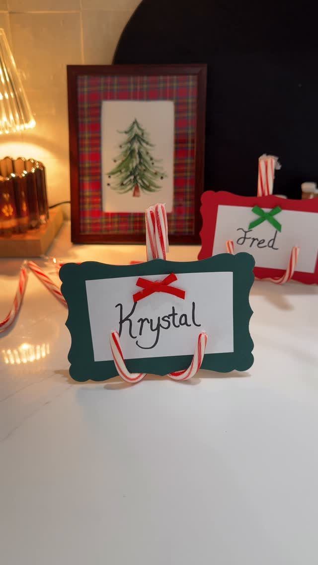 12 Xmas Table Decorations for Pine Cones, Mercury Glass, and Blue-Gold Palettes 2 Two scalloped Christmas place cards held by candy canes on a white table.